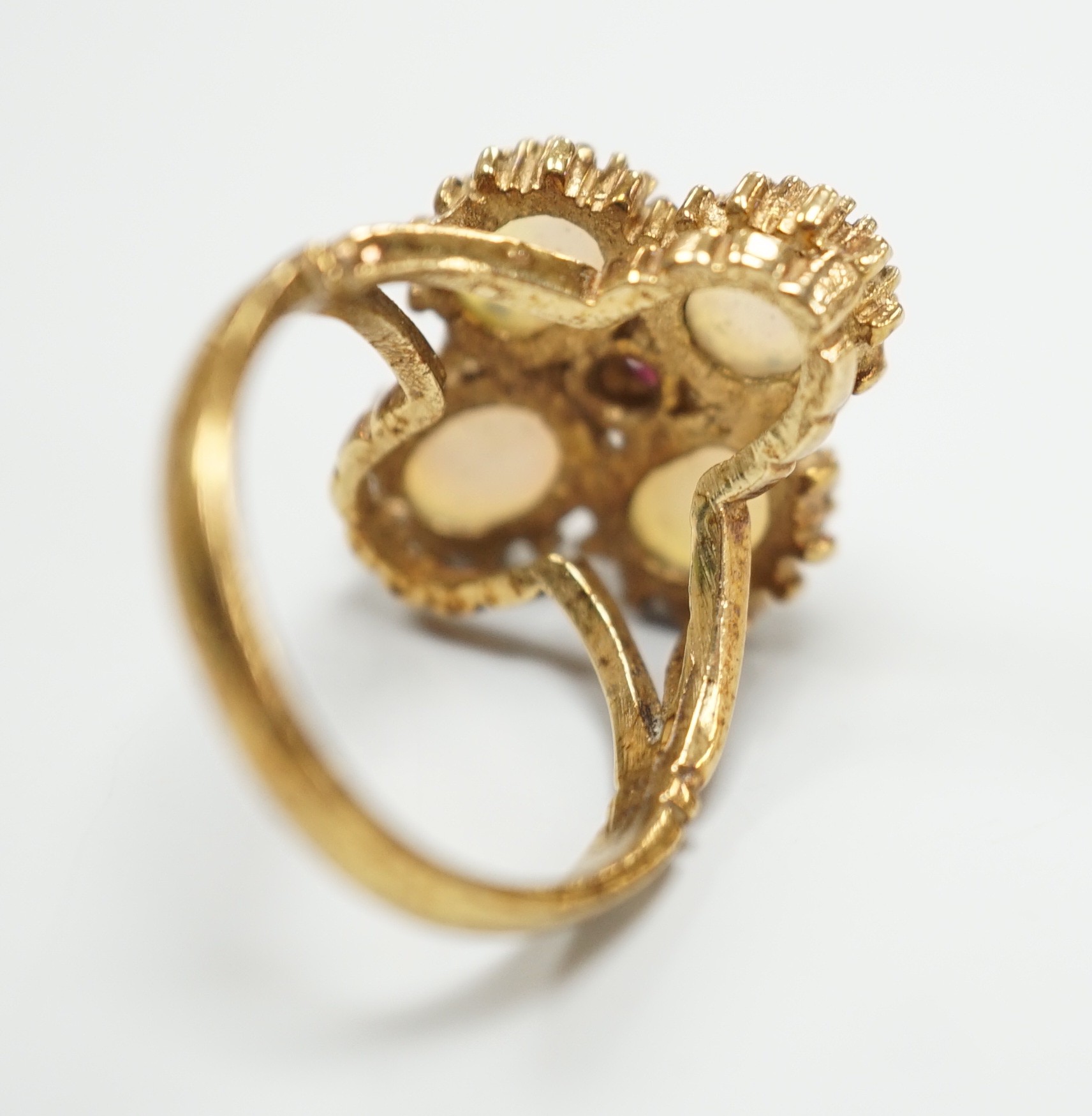 A 1970's 9ct gold, four stone white opal and single stone ruby cluster set dress ring, size O, gross weight 5.2 grams.